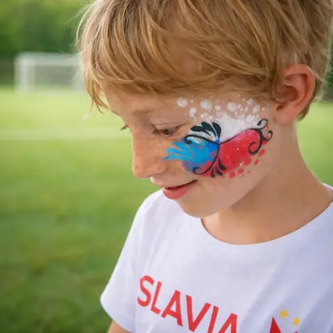 Motýl namalovaný na obličeji chlapce