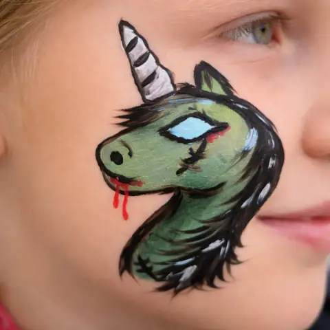Zelený jednorožec namalovaný na tváři