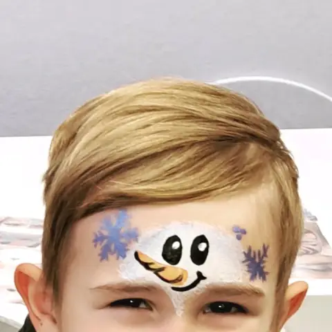Sněhulák namalovaný na čele dítěte